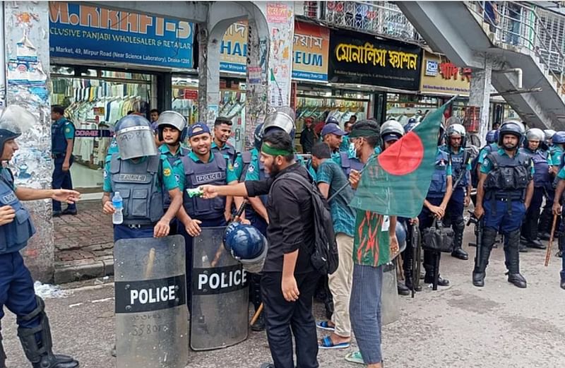 সহিংসতার মধ্যেও পুলিশ সদস্যদের বিস্কুট দিচ্ছিলেন আন্দোলনকারীরা। রাজধানীর সায়েন্স ল্যাব মোড়ে, শনিবার দুপুরে।